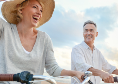 young couple biking on beach